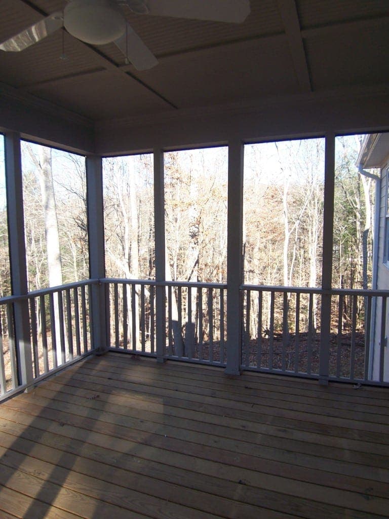 Finished screened porch with wood flooring and ceiling fan