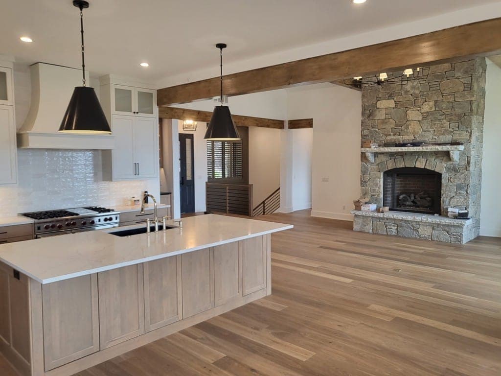 Open kitchen with stone fireplace in whole home remodel