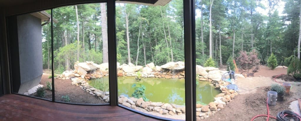 Backyard view with pond and forest at Green River home